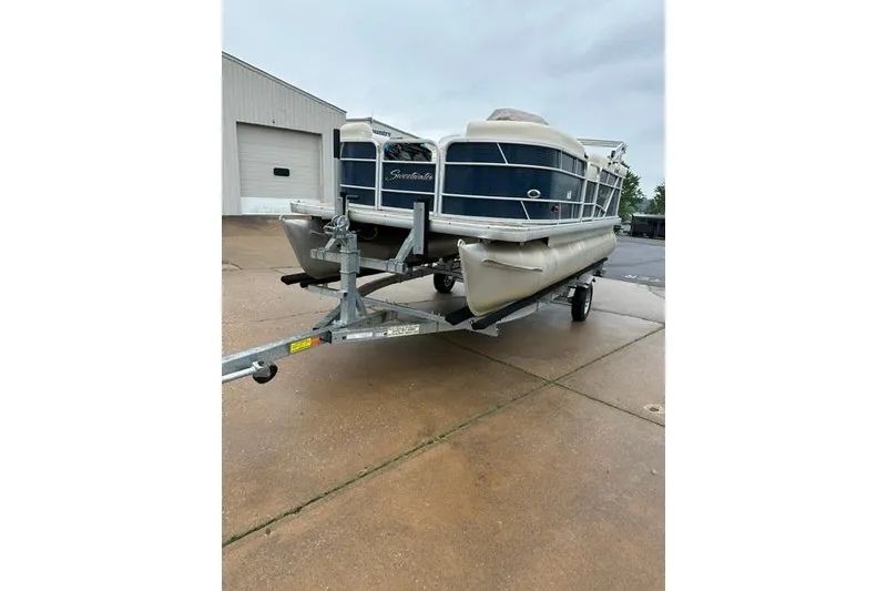 The Image of 2015 Godfrey Sweetwater 1880 CX pontoon boat on trailer, parked outdoors. - 1