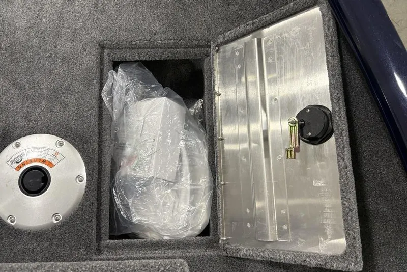 Slide: The Image of 2026 Tracker Super Guide V-16 SC boat compartment with storage and control panel. - 14