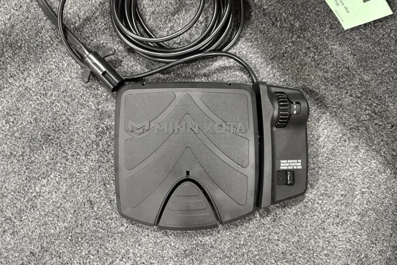 Slide: The Image of Minn Kota foot pedal on Tracker Super Guide V-16 SC, 2026 model, on carpeted surface. - 15