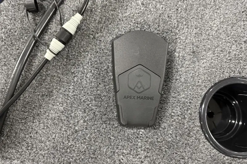 Slide: The Image of Apex Marine device on Tracker Super Guide V-16 SC 2026 boat carpet with cables. - 16