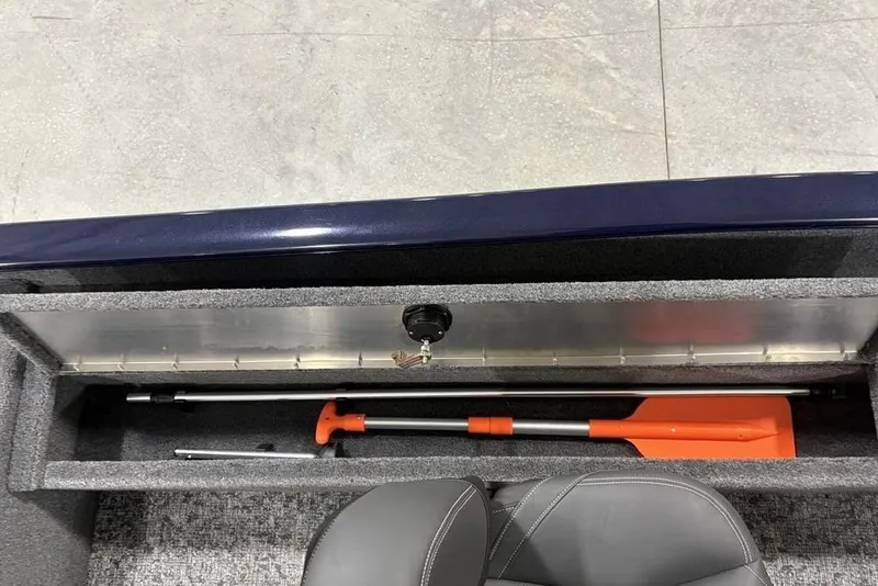 Slide: The Image of Storage compartment of 2026 Tracker Super Guide V-16 SC boat with paddle and seat. - 17