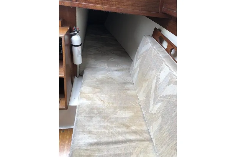 Slide: The Image of Interior cabin of a 1995 Com-Pac 25 sailboat with beige seating and a fire extinguisher. - 11