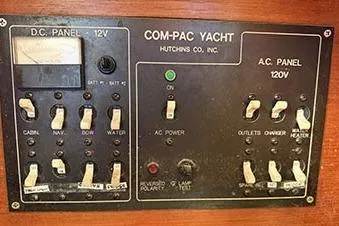 Slide: The Image of Control panel of a 1995 Com-Pac 25 yacht, featuring DC and AC switches. - 15