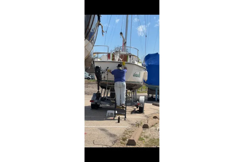 Slide: The Image of Person working on a 1995 Com-Pac 25 sailboat on a trailer. - 18