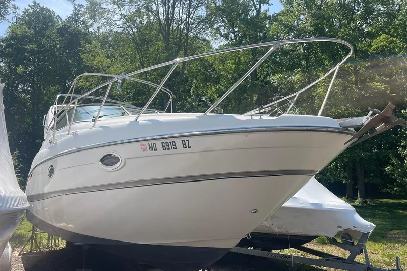 Slide: The Image of 2002 Maxum 2700 SCR boat on trailer, surrounded by trees. - 1