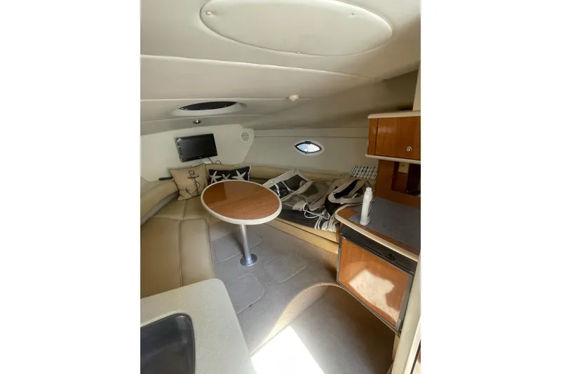 Slide: The Image of Interior of 2002 Maxum 2700 SCR boat with seating, table, and small kitchenette. - 12