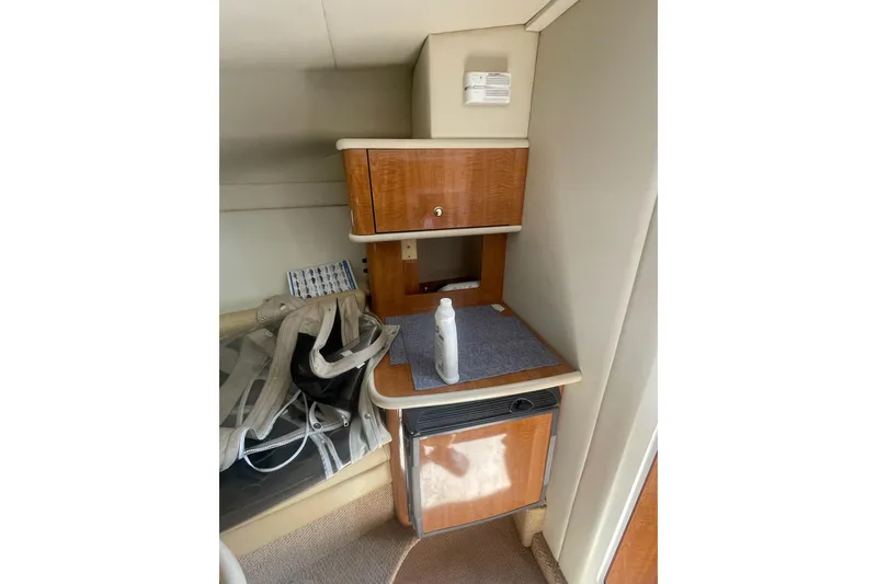 Slide: The Image of 2002 Maxum 2700 SCR cabin interior with wooden cabinetry and compact fridge. - 14
