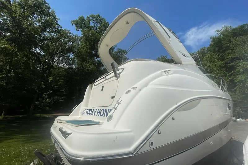 Slide: The Image of 2002 Maxum 2700 SCR boat with sleek design, parked outdoors under a clear blue sky. - 3