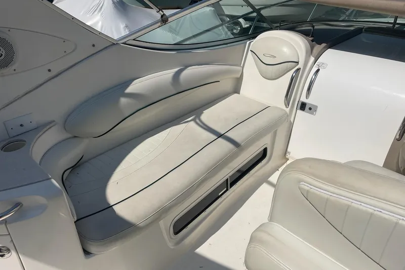 Slide: The Image of Interior seating of a 2002 Maxum 2700 SCR boat, featuring white cushioned seats. - 7