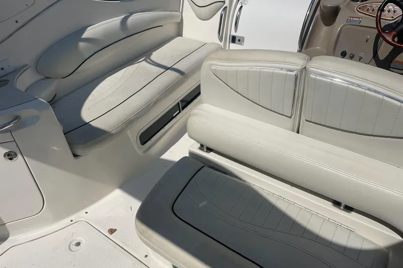 Slide: The Image of Interior seating of 2002 Maxum 2700 SCR boat, featuring white cushioned seats. - 8