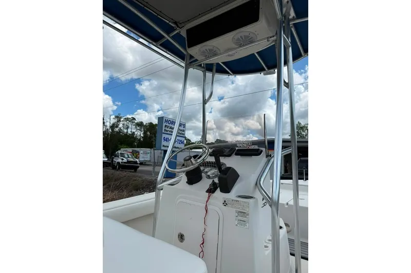 Slide: The Image of 2016 Sea Chaser 21 Sea Skiff boat console with steering wheel and canopy. - 7