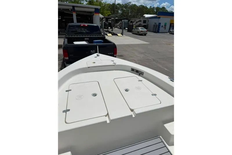 Slide: The Image of 2016 Sea Chaser 21 Sea Skiff boat on trailer, parked near a truck. - 9
