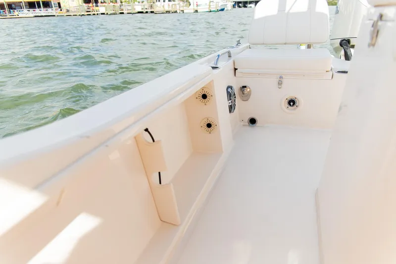 Slide: The Image of 2024 Grady-White 231 Coastal Explorer boat interior with seating and storage, on water. - 12