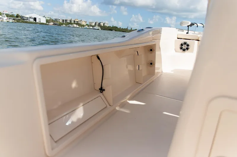 Slide: The Image of 2024 Grady-White 231 Coastal Explorer boat interior with storage compartments and scenic water view. - 13