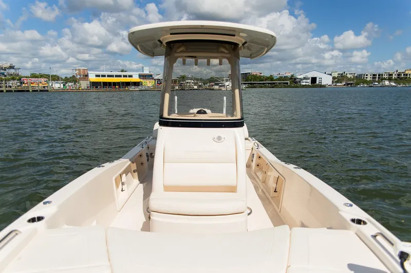 Slide: The Image of 2024 Grady-White 231 Coastal Explorer boat on water, showcasing spacious deck and helm. - 14