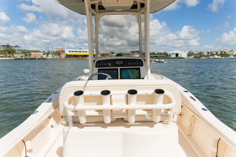 Slide: The Image of 2024 Grady-White 231 Coastal Explorer boat on water, featuring rod holders and console. - 27