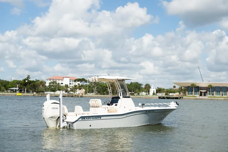 Slide: The Image of 2024 Grady-White 231 Coastal Explorer boat on calm water under a partly cloudy sky. - 3