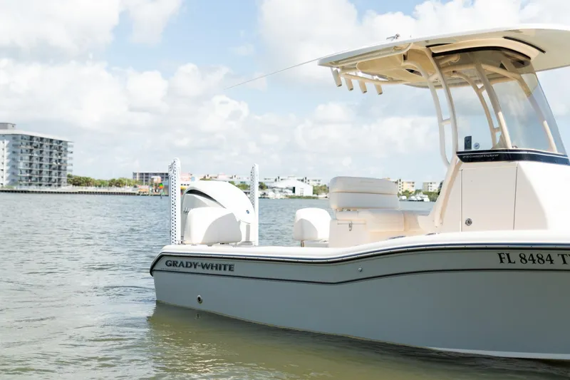 Slide: The Image of 2024 Grady-White 231 Coastal Explorer boat on calm water, cityscape background. - 5