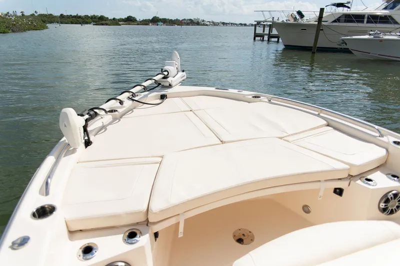 Slide: The Image of 2024 Grady-White 231 Coastal Explorer boat with spacious deck, docked on calm waters. - 9