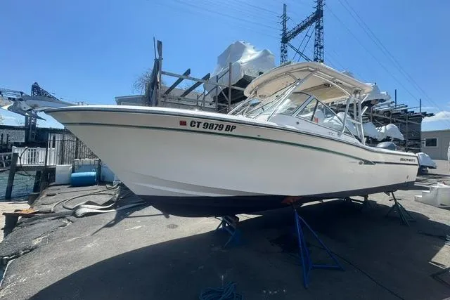 The Image of 2012 Grady-White Freedom 275 boat on stands, dockside, under clear blue sky. - 0