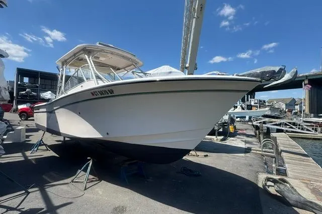 Slide: The Image of 2012 Grady-White Freedom 275 boat docked at marina under clear blue sky. - 1