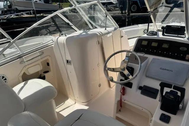 Slide: The Image of 2012 Grady-White Freedom 275 boat cockpit with steering wheel and Garmin navigation system. - 10