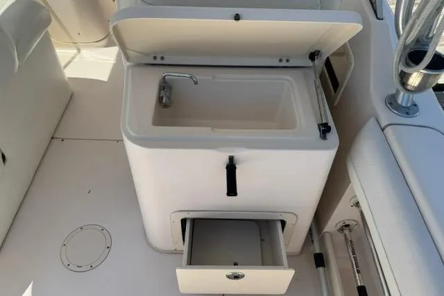 Slide: The Image of 2012 Grady-White Freedom 275 boat sink and storage compartment. - 17