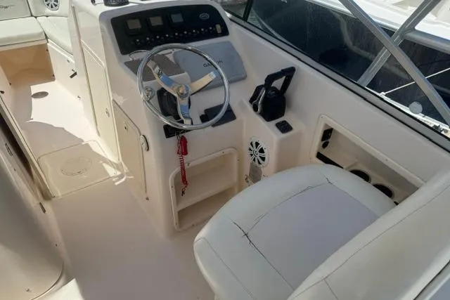 Slide: The Image of 2012 Grady-White Freedom 275 boat cockpit with steering wheel and control panel. - 18