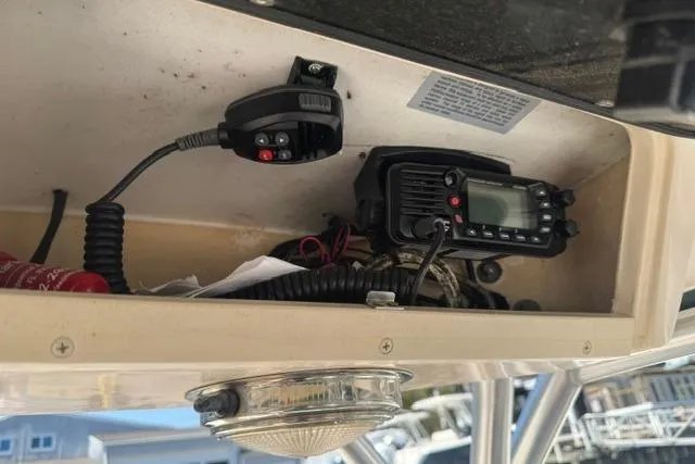 Slide: The Image of 2012 Grady-White Freedom 275 boat radio and controls in storage compartment. - 22