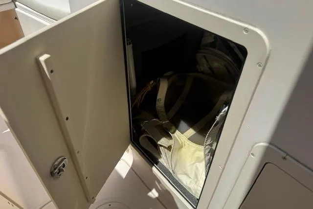 Slide: The Image of Open storage compartment on 2012 Grady-White Freedom 275 boat, revealing interior contents. - 24