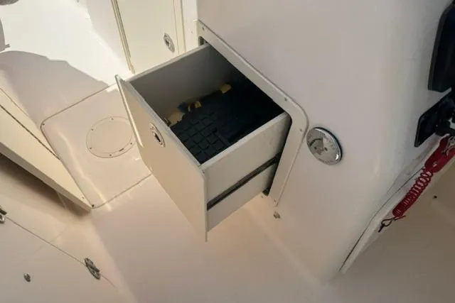 Slide: The Image of Storage compartment on a 2012 Grady-White Freedom 275 boat, partially open with visible contents. - 25