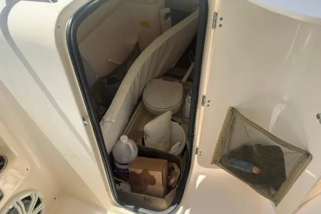 Slide: The Image of 2012 Grady-White Freedom 275 boat interior storage area with various items. - 26