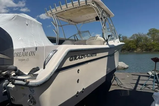 Slide: The Image of 2012 Grady-White Freedom 275 boat docked by the water under a clear blue sky. - 3