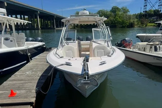 Slide: The Image of 2012 Grady-White Freedom 275 boat docked by a river under a bridge. - 6