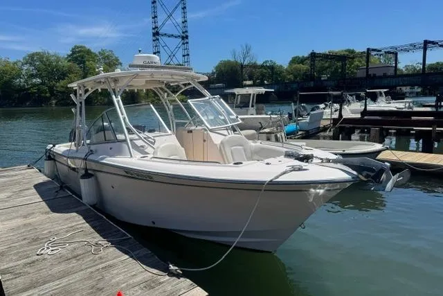 Slide: The Image of 2012 Grady-White Freedom 275 boat docked at a marina under clear blue skies. - 7