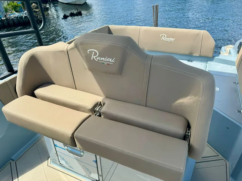 Slide: The Image of 2025 Ranieri CAYMAN 28 EXECUTIVE boat with beige seating, docked by the water. - 8
