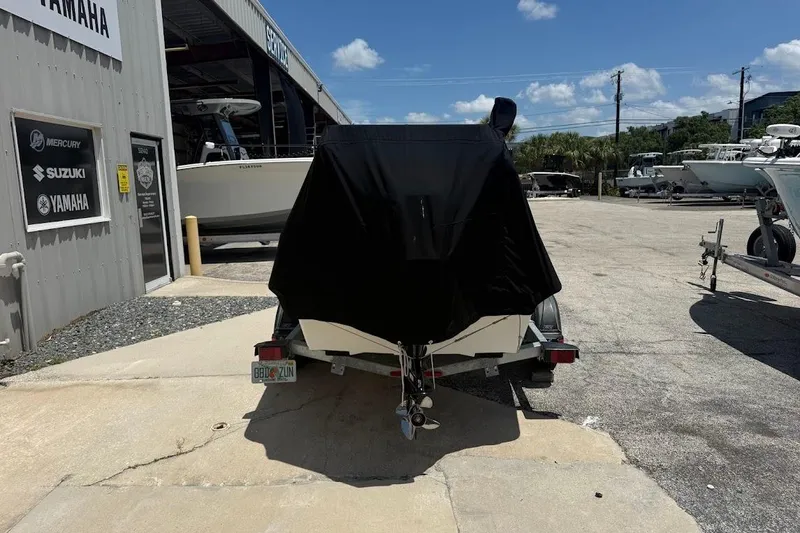 Slide: The Image of 2024 Delta D18 boat covered on trailer at dealership, sunny day. - 3