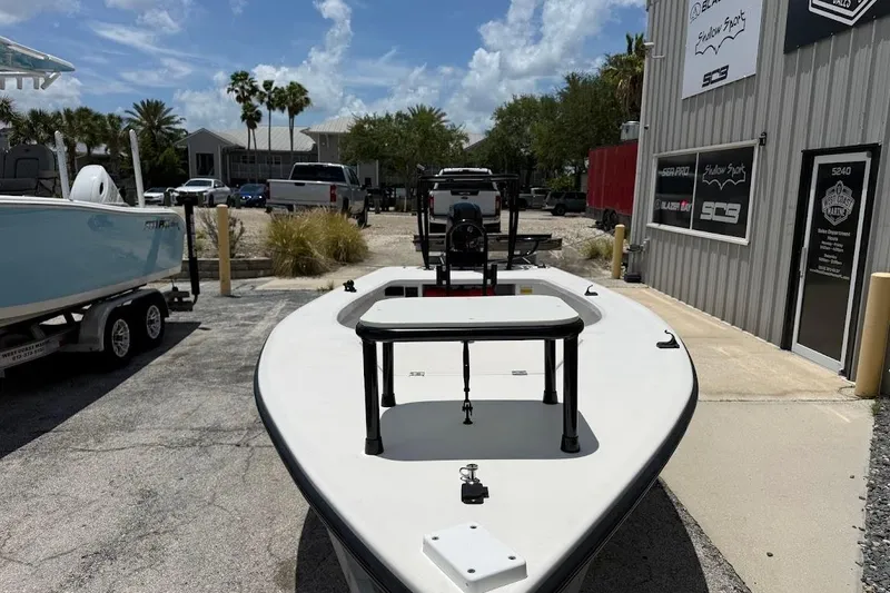 Slide: The Image of 2024 Delta Boatworks Delta D18 skiff displayed outdoors near a marine shop. - 4