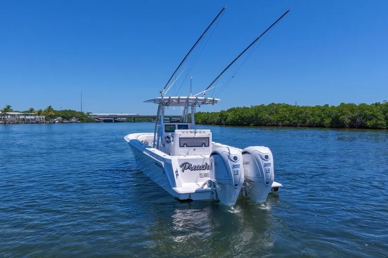 Slide: The Image of 2025 Contender 32 ST boat with dual engines on a calm waterway. - 10