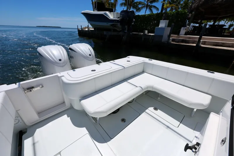 Slide: The Image of 2025 Contender 32 ST boat with white seating and dual engines docked by the water. - 13