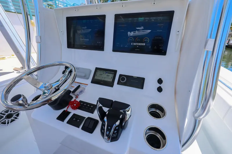 Slide: The Image of 2025 Contender 32 ST boat dashboard with dual screens and steering wheel. - 17