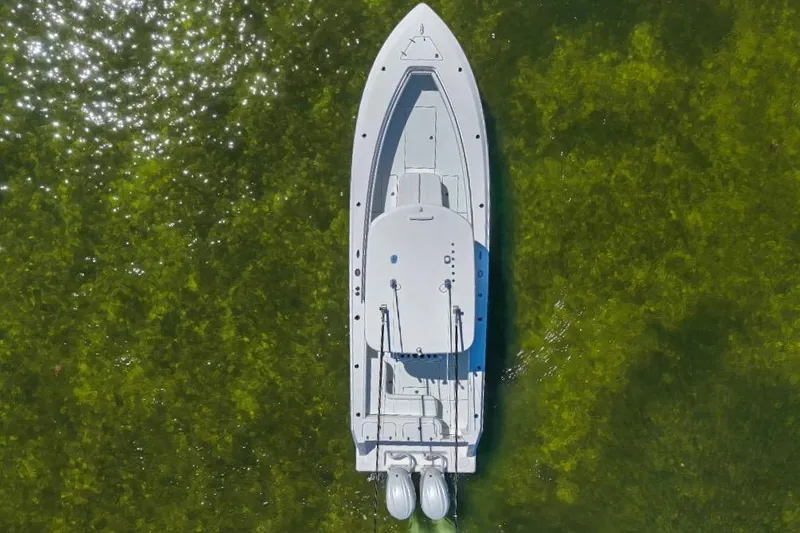 Slide: The Image of Aerial view of 2025 Contender 32 ST boat on clear green water. - 26