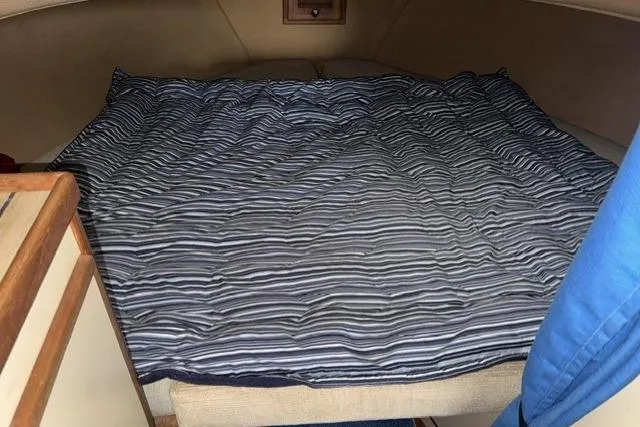 Slide: The Image of Cozy cabin bed in 1983 Nordic Tug 26 boat with striped bedding. - 13