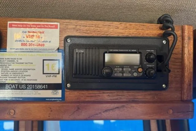 Slide: The Image of VHF radio and emergency call instructions on a 1983 Nordic Tug 26 boat. - 18