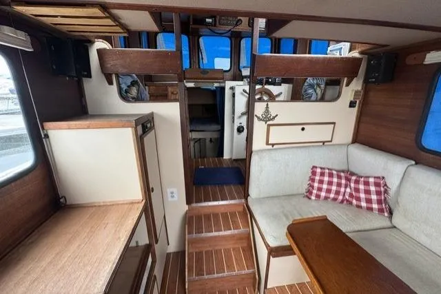 Slide: The Image of Interior of a 1983 Nordic Tug 26, featuring cozy seating and nautical decor. - 4