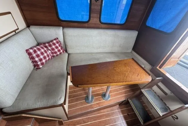 Slide: The Image of Interior of 1983 Nordic Tug 26 with wooden table and cushioned seating. - 9