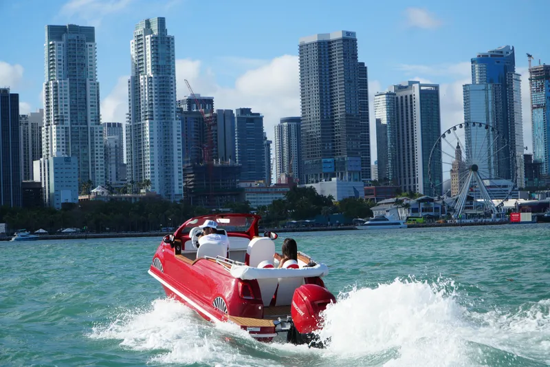 Slide: The Image of Red boat cruising near city skyline with Ferris wheel, 2025 Car Off-shore Fiat 500 Classic. - 17