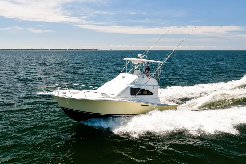 The Image of 1994 Luhrs 38 Convertible yacht cruising on open water under clear skies. - 1