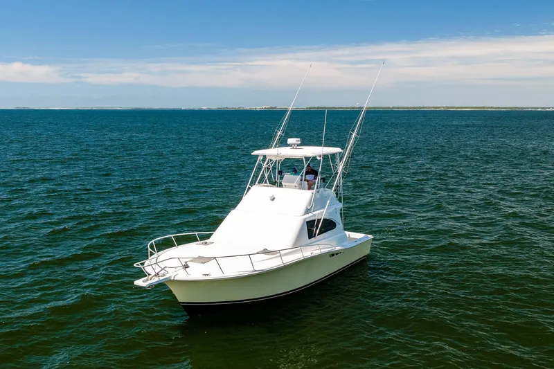 Slide: The Image of 1994 Luhrs 38 Convertible boat cruising on open water under clear skies. - 12