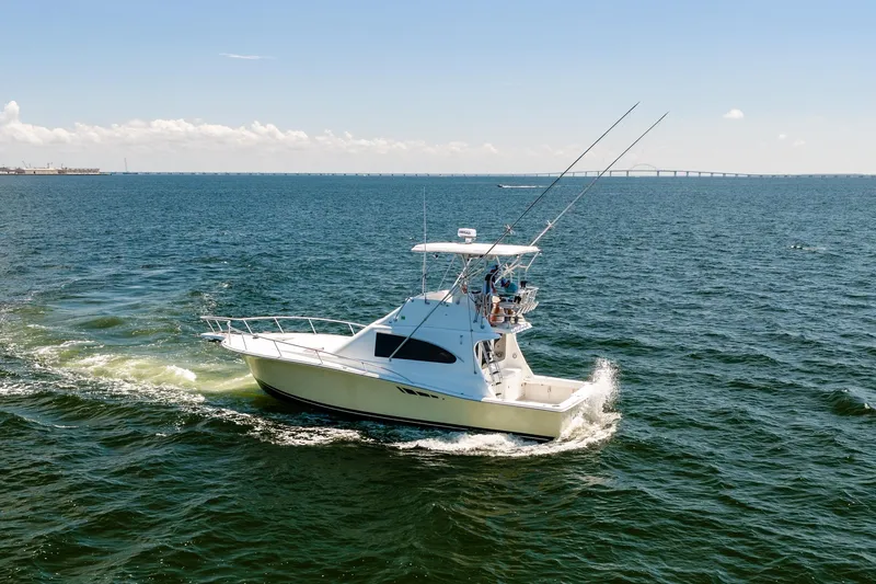 Slide: The Image of 1994 Luhrs 38 Convertible yacht cruising on open water under clear skies. - 16